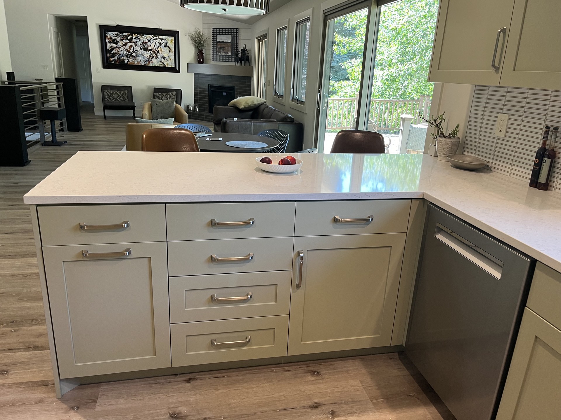Sage green peninsula with quartz countertop in a Holladay-style kitchen